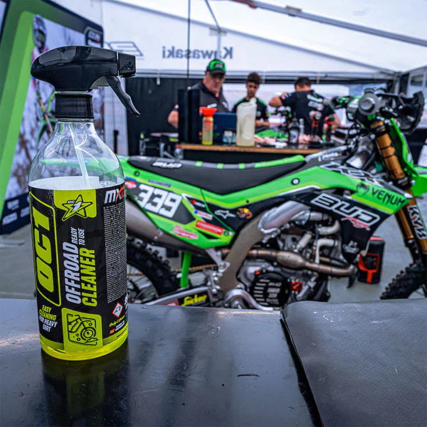 Aplikacja środka czyszczącego OC1 Offroad Cleaner na zabrudzone błotem koło motocykla terenowego &ndash; skuteczne czyszczenie bez szorowania